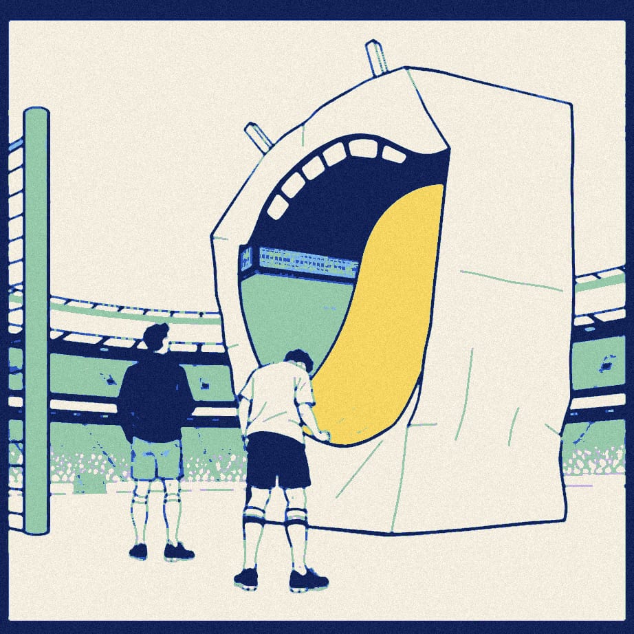 An enormous cardboard smile propped against a stadium gate while a faceless player in white is comforted from behind by a figure in dark clothing.