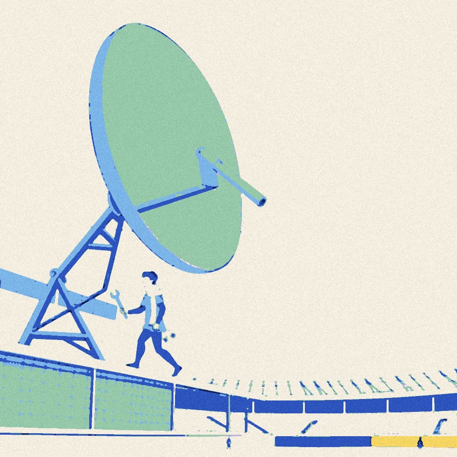 A tiny supporter fixes a giant satellite dish to stadium railings in front of a huge rippling flag.