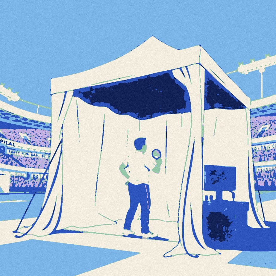 A supporter in a white shirt, seen from behind, examines a table with a magnifying glass inside a garden gazebo pitched outside a giant stadium, next to a desk of microphones.