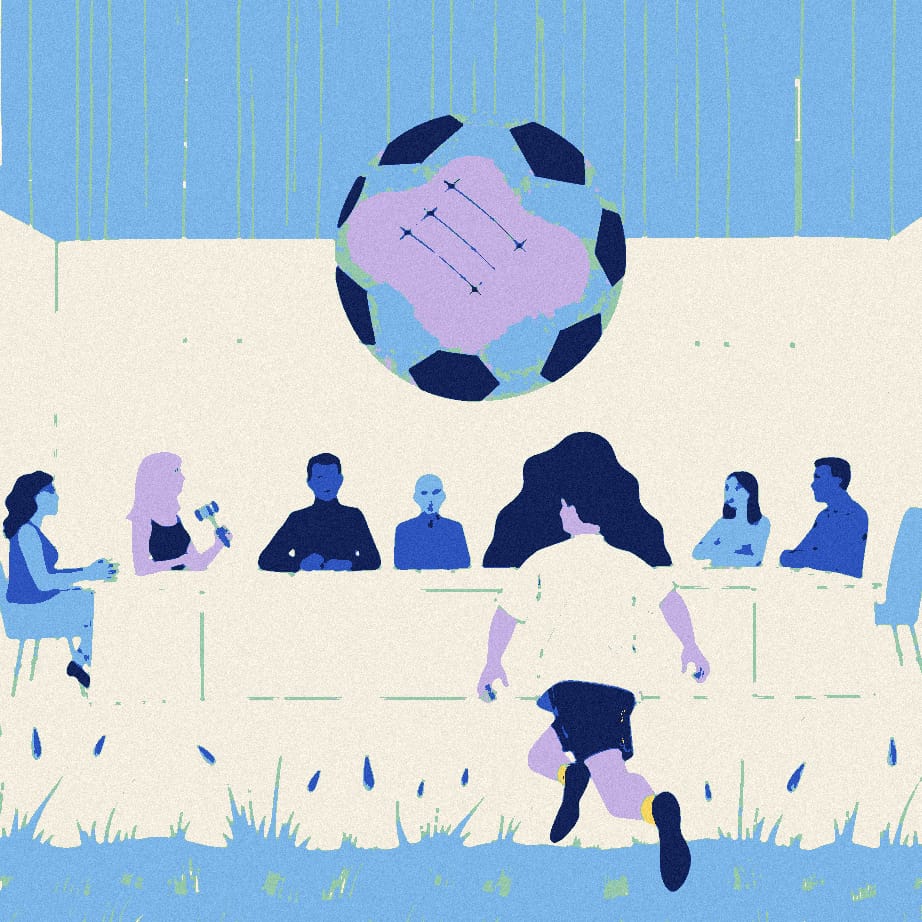 A parish council sits around a table with a giant football on it while an anonymous player in white jogs past in the rain.