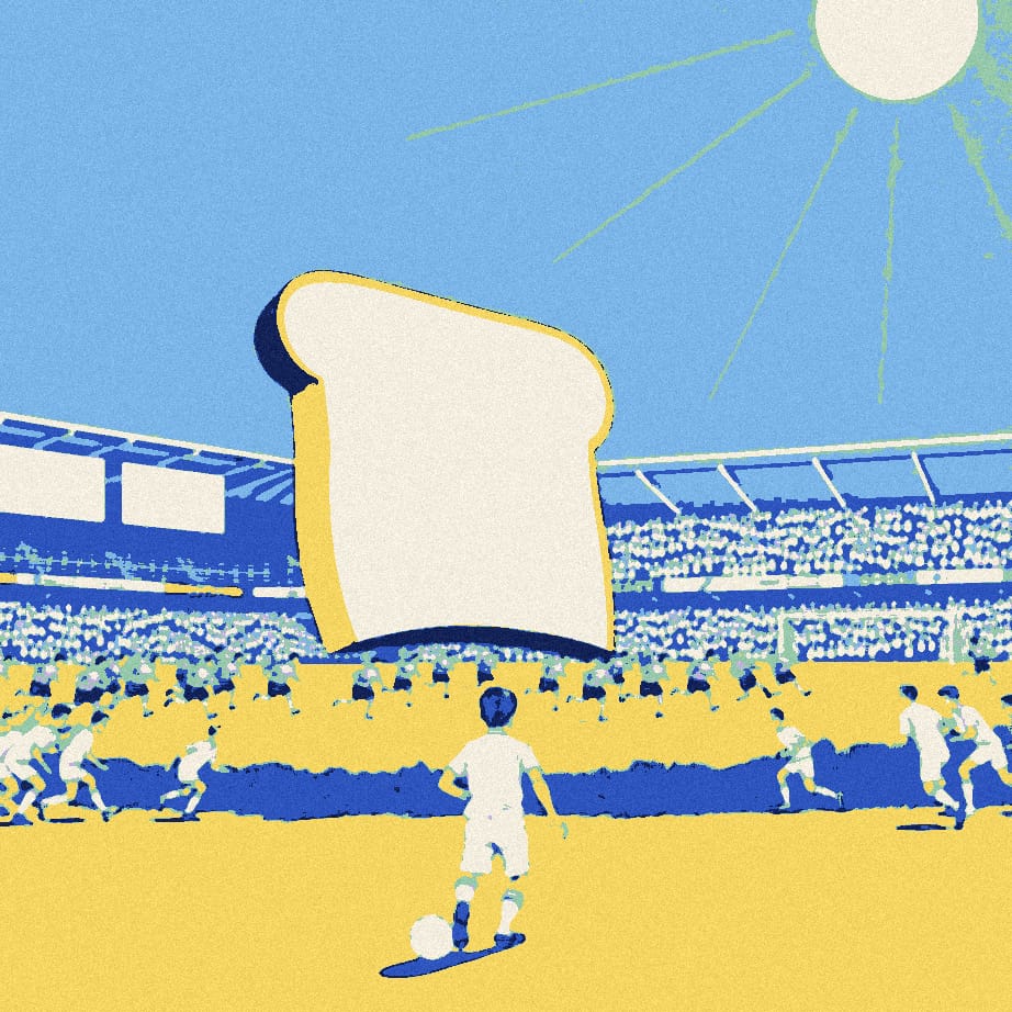 A tiny footballer dribbles a ball past a house-sized slice of toast while small figures scramble around it on a sunny pitch.