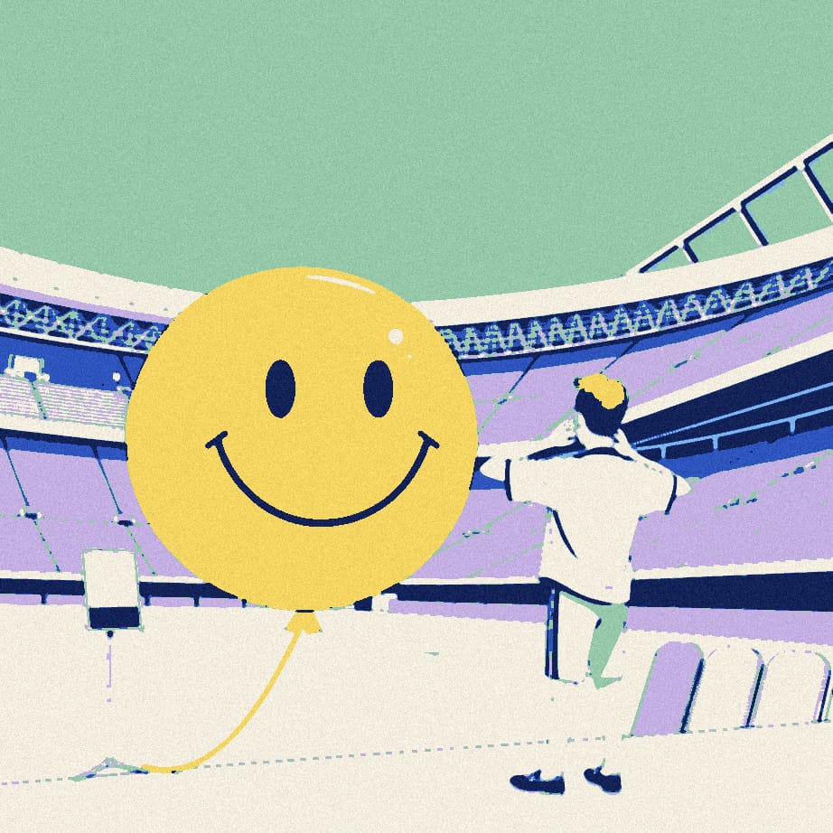 A small supporter in a white shirt, seen from behind, practises a smile in a mirror beneath a huge smiley balloon on a stadium forecourt.