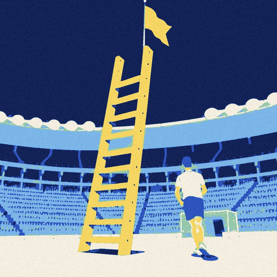 A tiny supporter stands on the lowest rung of a giant stepladder beside a corner flag in a floodlit stadium at night.