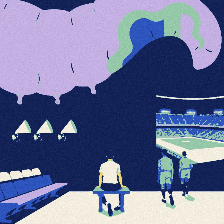 A hunched player sits on a tunnel bench while six megaphones of growing size sit in a row beside him and two teammates walk toward the pitch.