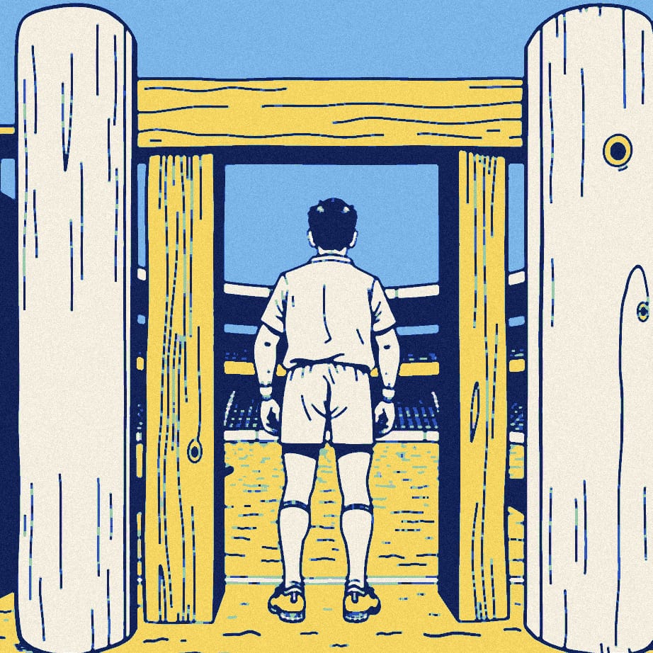 An anonymous player in a plain white shirt, seen from behind, squeezes through a tiny turnstile at a small, empty lower-league ground.