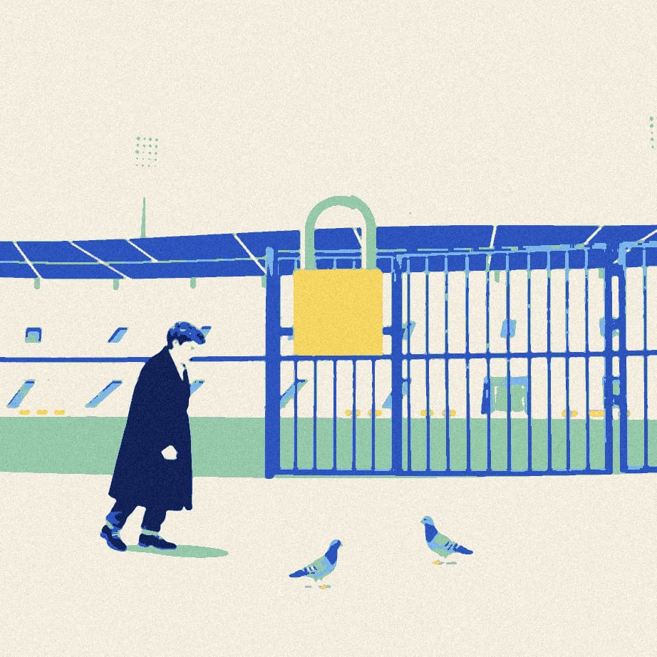 A man in a long coat pushes his shoulder against a closed stadium gate fitted with an enormous padlock, on an empty forecourt.