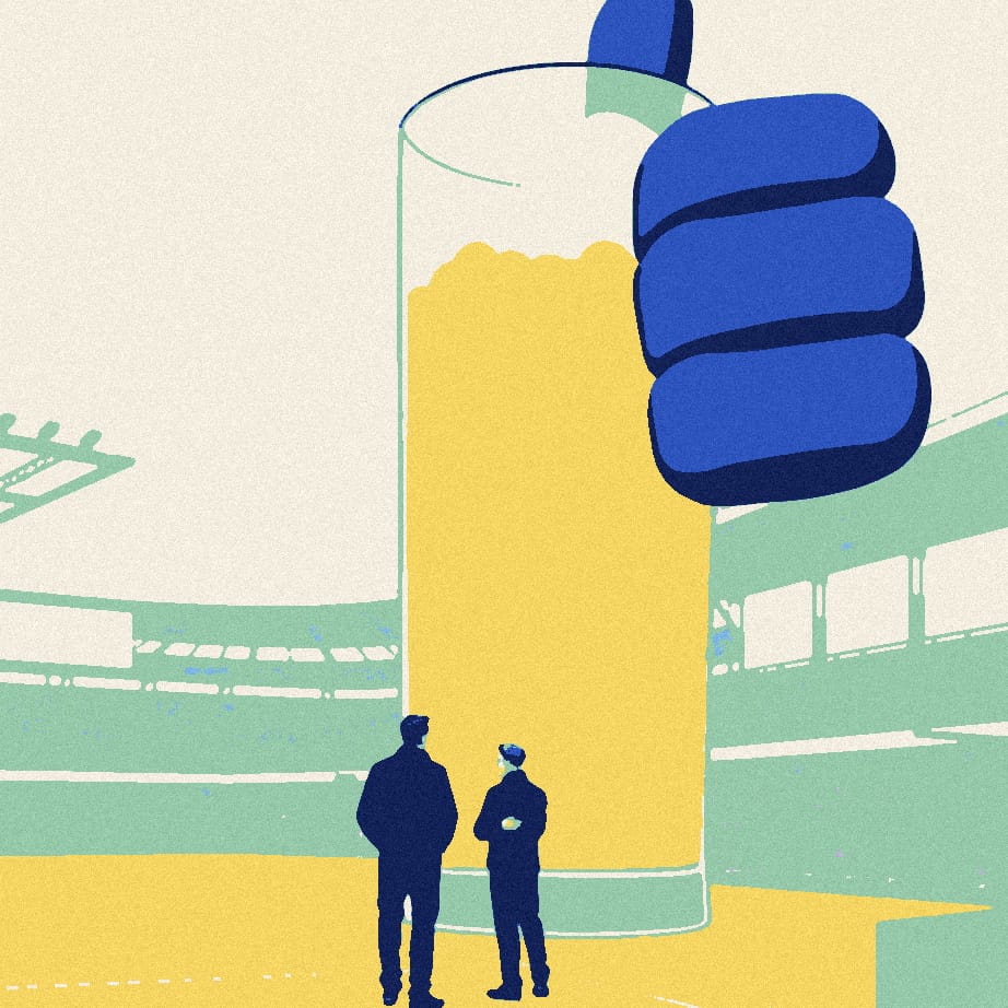 A small coach seen from behind shouts on a sunny touchline beside a giant pint glass filled with coins.
