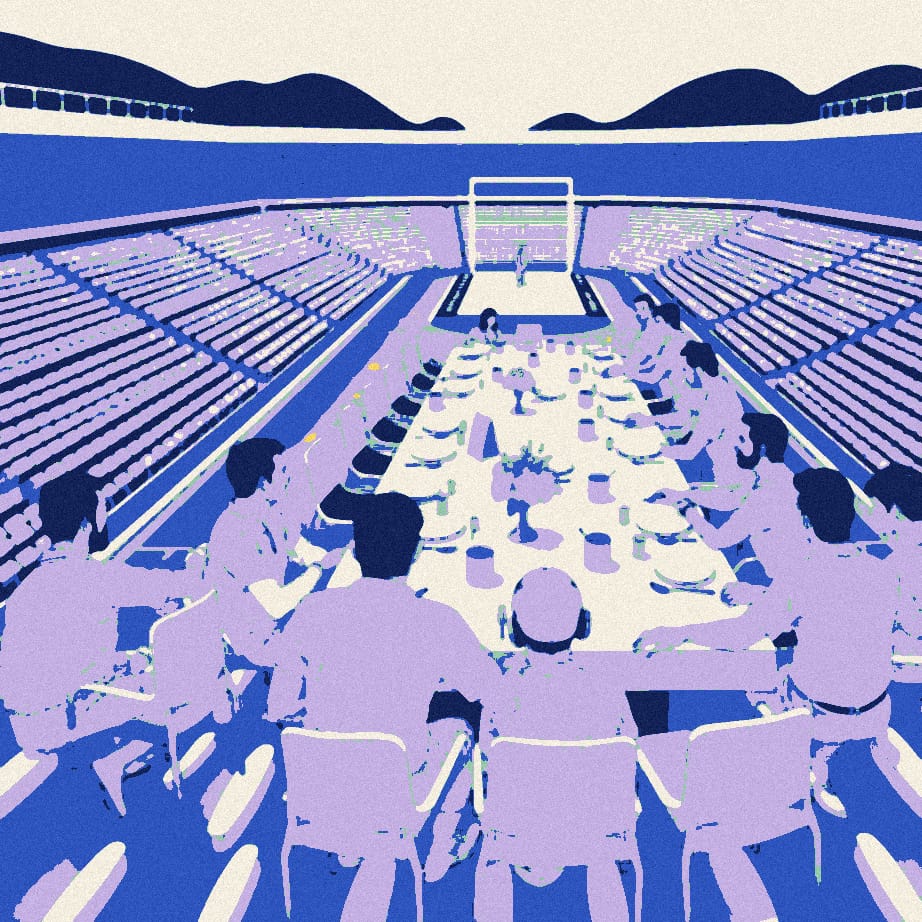 A tiny lone supporter sits at a small table for one at the end of a huge banquet table where a huddle of faceless players dine together in a night-time stadium.